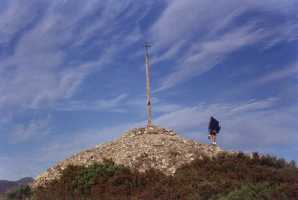 Un peregrino rezando al llegar a la Cruz de Hierro